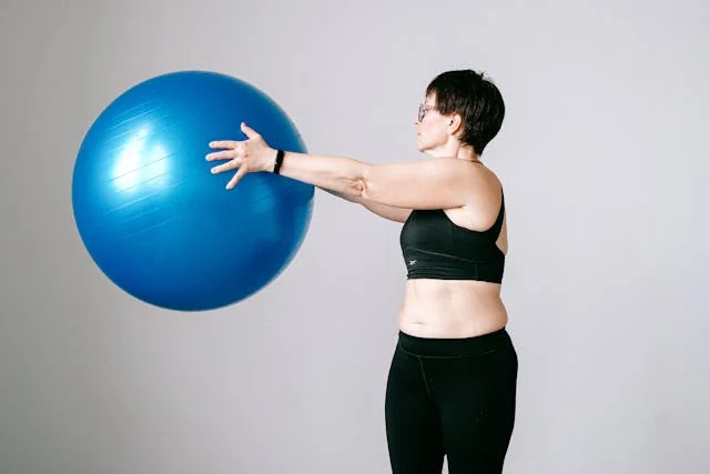 Woman holding a large blue stability ball