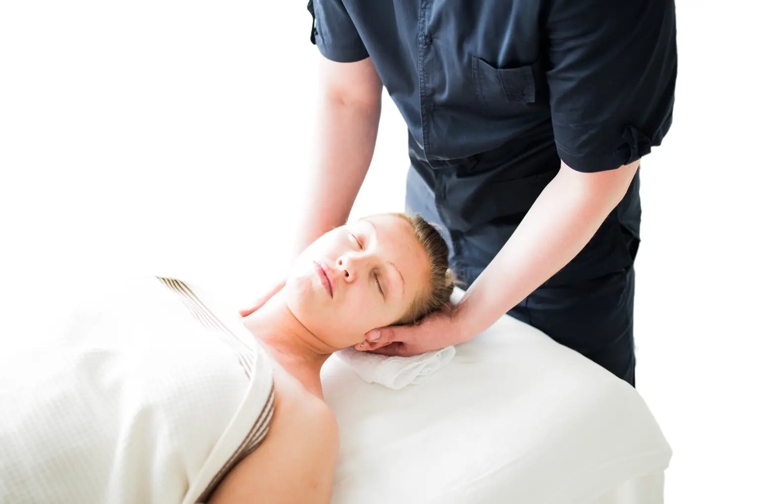 Massage therapist supporting a client’s head and neck during a focused treatment